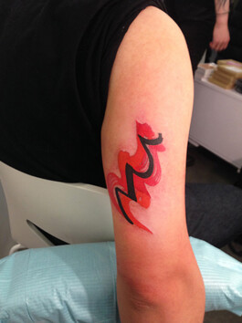 Pink and orange tattoo on arm 