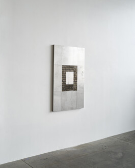 Shiny steel sculpture on a wall 