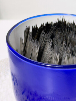 Blue teacup with tattoo needles inside 